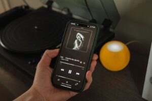Transform Your Home: Sonos Smart Integration Tips 3 a person holding a cell phone in front of a record player